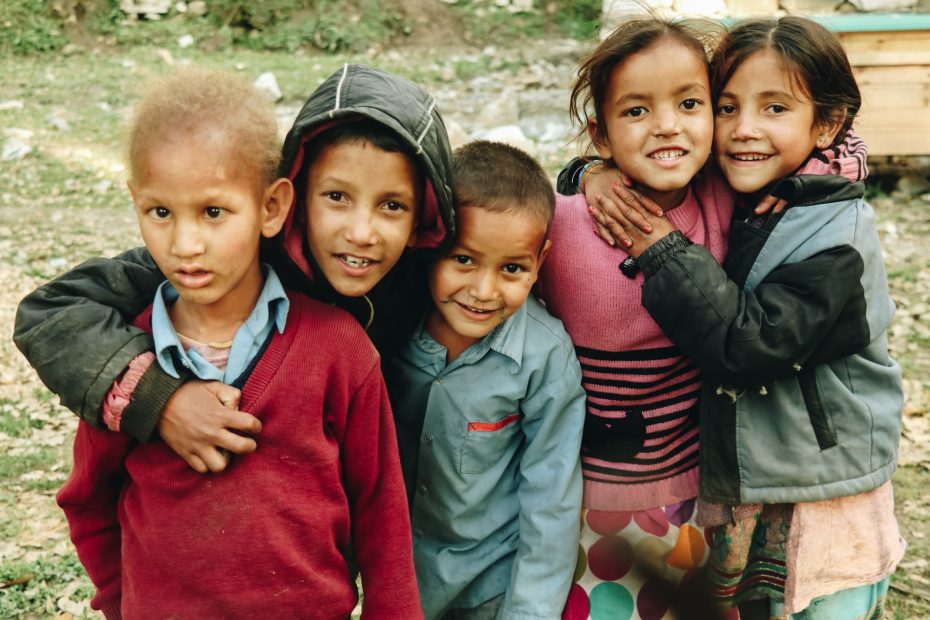 group of children standing on grass field during daytime