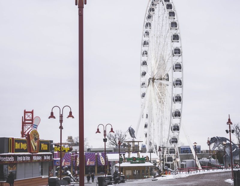 white ferris wheel near white and red building during daytime