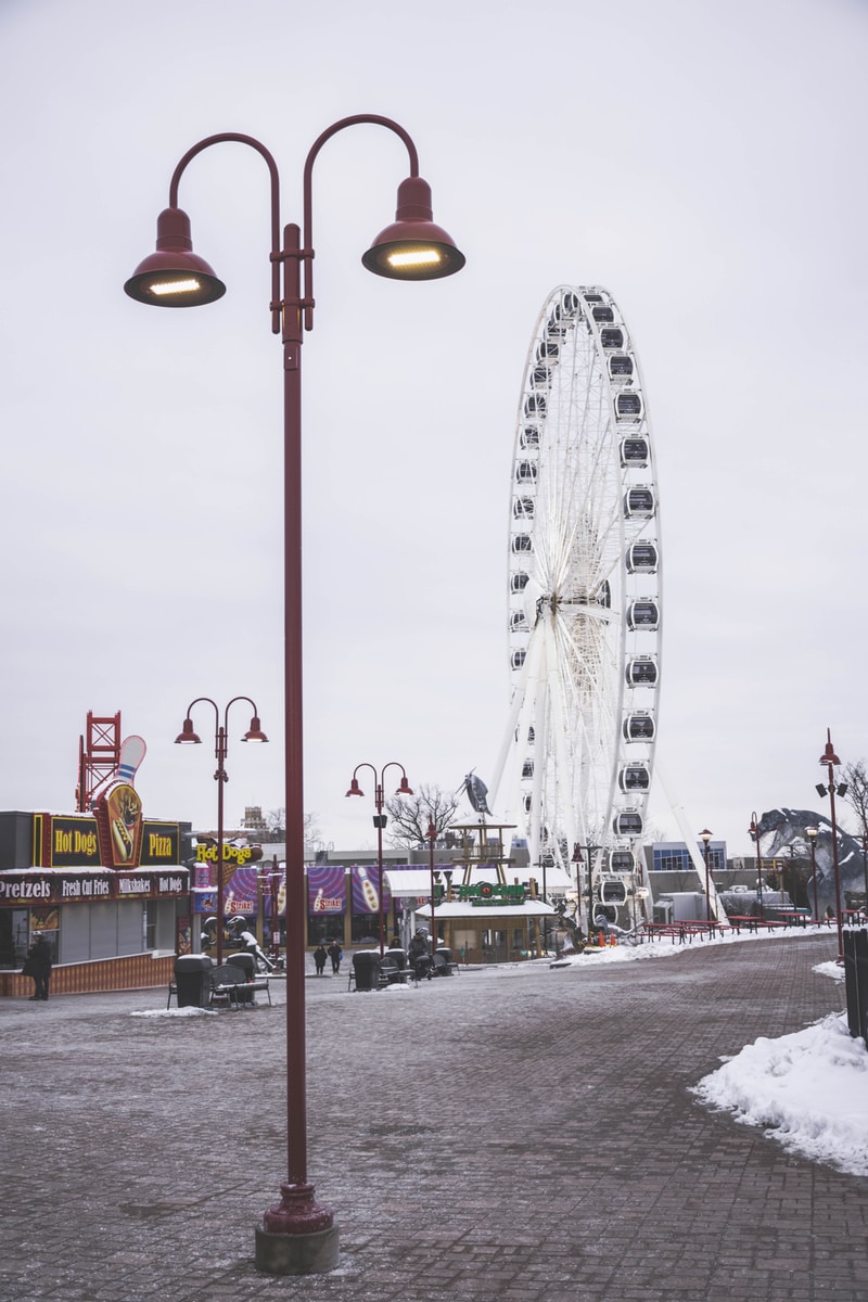 white ferris wheel near white and red building during daytime