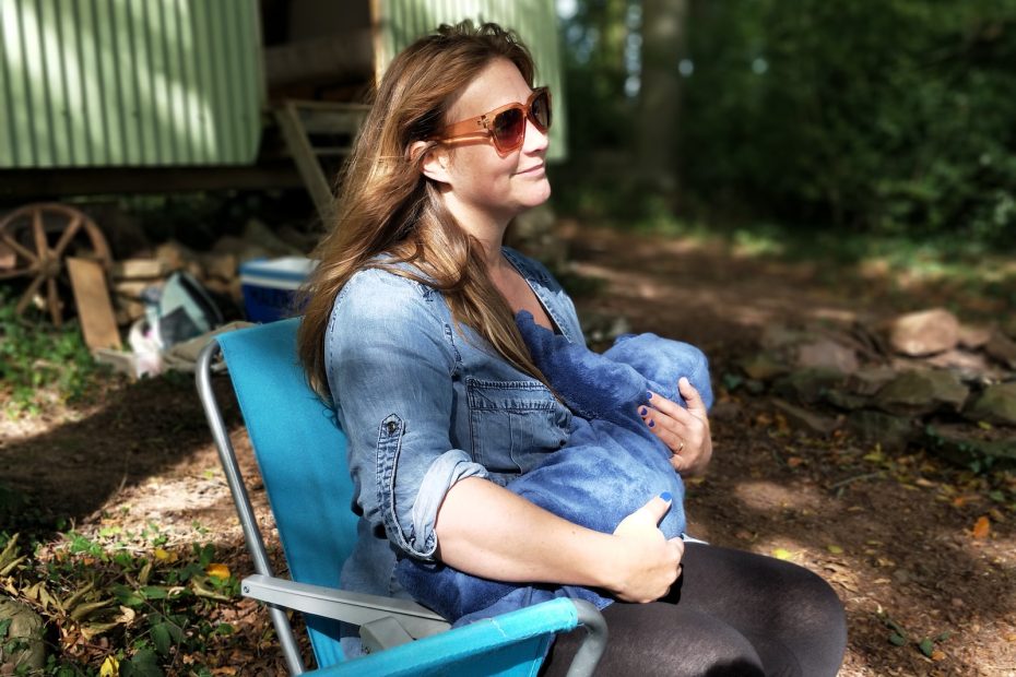 woman carrying baby while sitting on chair