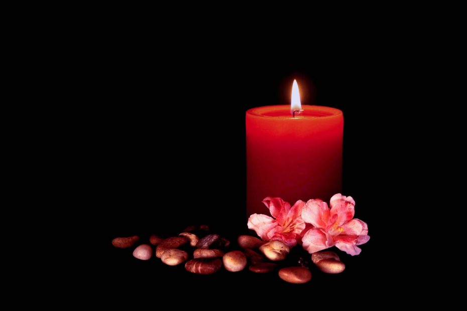 a candle and some nuts on a black background