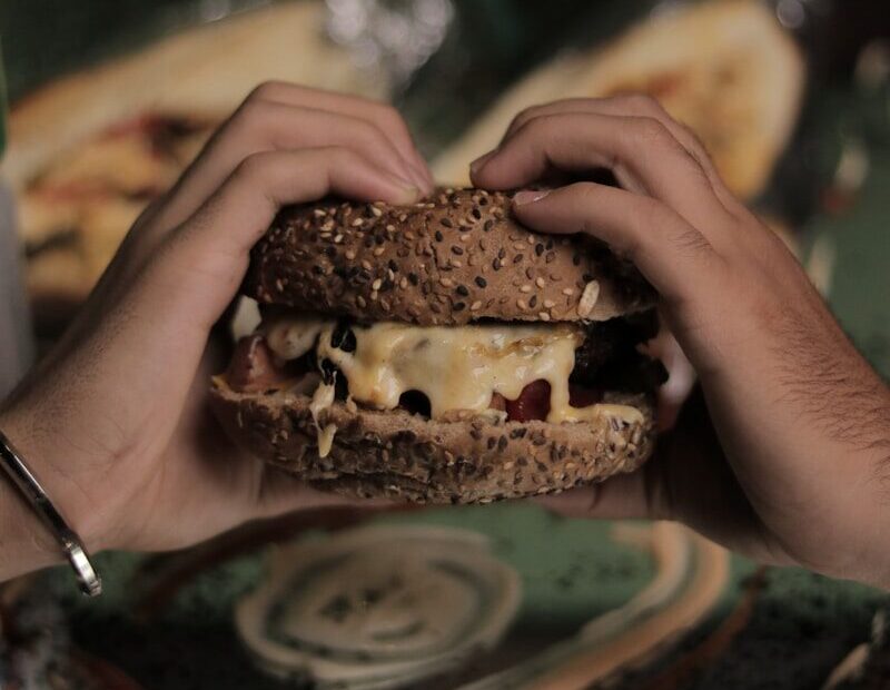 a person holding a sandwich in their hands