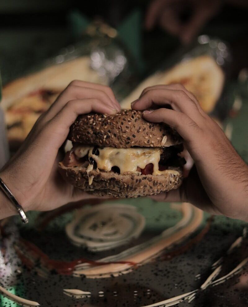 a person holding a sandwich in their hands