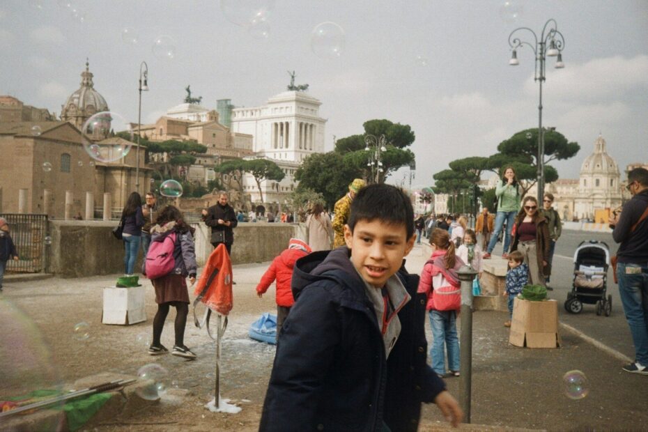 boy in black jacket standing near people during daytime