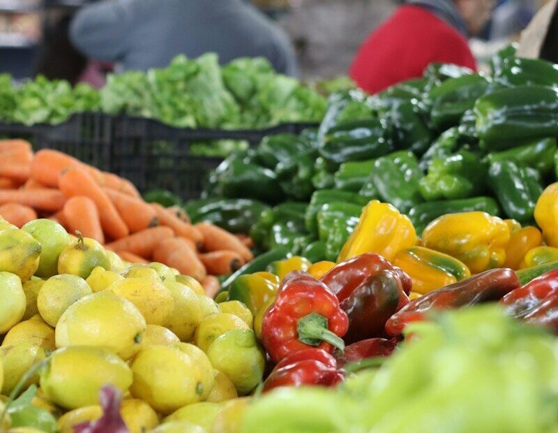 Fresh produce is displayed at a lively farmer's market